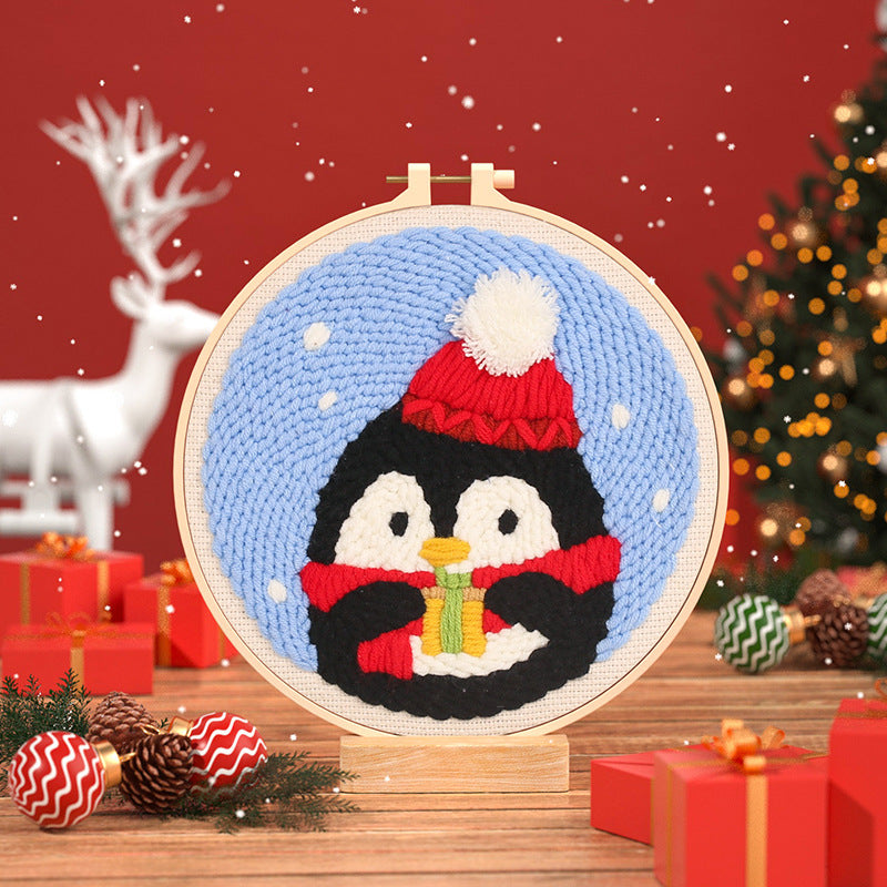 Winter Penguin Punch Needle Kit - penguin in a red winter hat and scarf against a snowy blue background