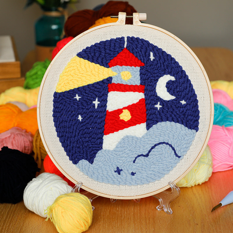Coastal Lighthouse Night Punch Needle red and white lighthouse design with a yellow beam on a dark blue night background